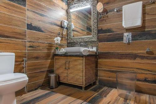 a wooden bathroom with a sink and a mirror at Silver wings Kasauli in Kasauli
