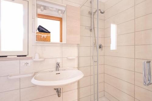 a white bathroom with a sink and a shower at Agriturismo Azzarone in Vieste