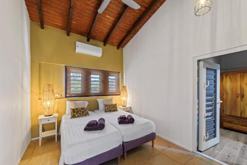 una camera da letto con un letto con due borse sopra di Villa CuraSea a Jan Thiel