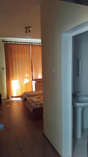 a bedroom with a bed and a toilet and a window at Интернационал in Kulata
