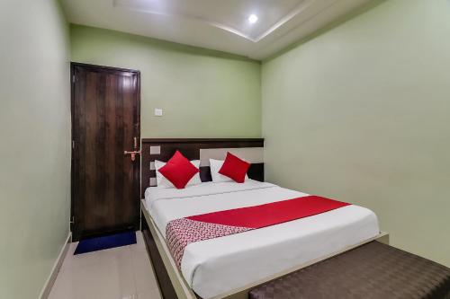 a bedroom with a bed with red pillows at Hotel O Royal in Rāj Nāndgaon