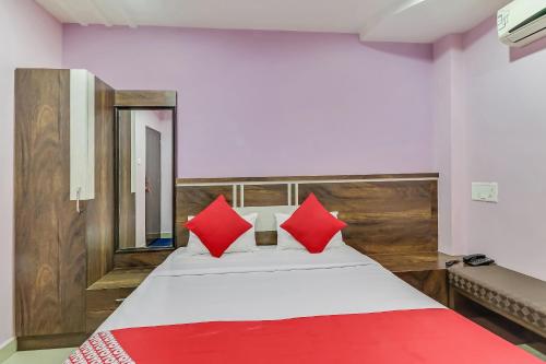 a bedroom with a large bed with red pillows at Hotel O Royal in Rāj Nāndgaon