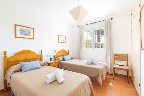 a bedroom with two beds and a window at Villa Maite by Escape Home in Binibeca