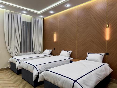 two beds in a hotel room with white sheets at Hotel VANGOGH in Kyzylorda
