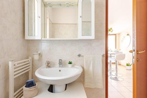 a white bathroom with a sink and a mirror at Lovely Flat with See View in Roseto degli Abruzzi