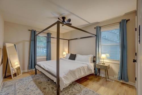 a bedroom with a canopy bed and two windows at Downtown Guest House in Raleigh