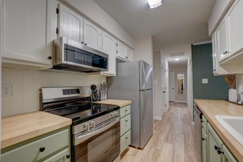 a kitchen with white cabinets and a stainless steel refrigerator at Downtown Guest House in Raleigh