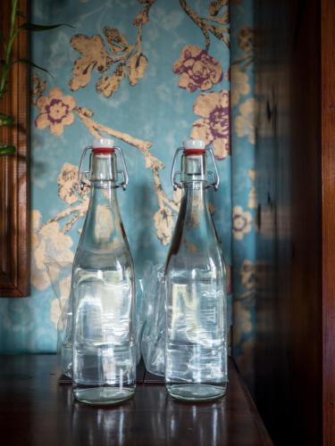 two empty glass bottles sitting on a table at Ash Farm Country House in Little Bollington