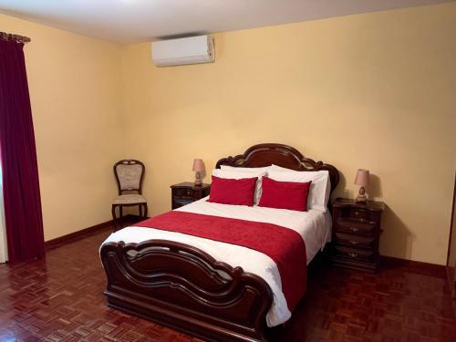 a bedroom with a large bed with red pillows at Mountain retreat in Boaventura