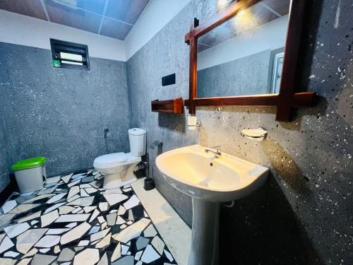 a bathroom with a sink and a toilet at Sea Paradise Hidden Villa in Tangalle
