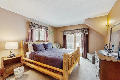 a bedroom with a bed and a dresser and a mirror at Snowy Day Chalet in Killington