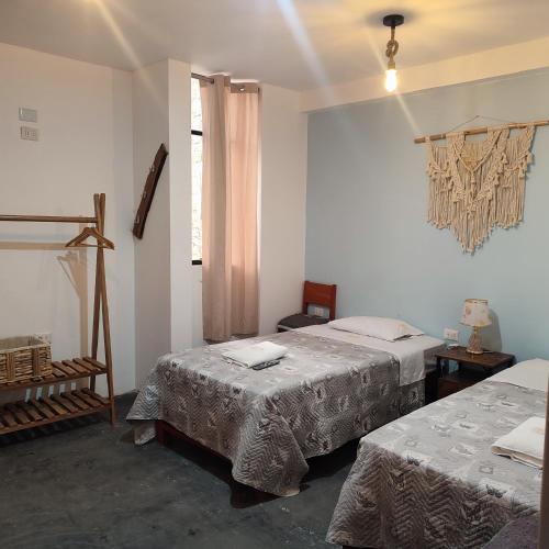 a room with two beds and a window at Hospedaje Velilu in Ica