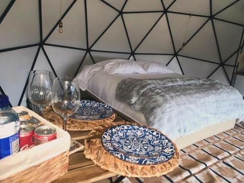 a table with plates and wine glasses on it at AWA ECO GlAMPING SPA in Villa de Leyva