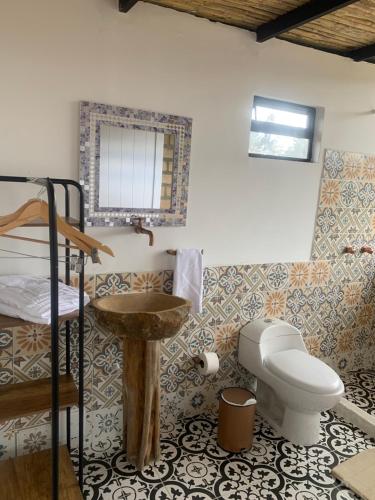 a bathroom with a toilet and a sink in a room at AWA ECO GlAMPING SPA in Villa de Leyva