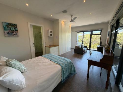 a bedroom with a bed and a desk and a chair at Octopus Room in Ballito