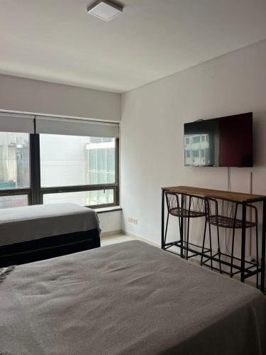 a bedroom with a bed and a table and a desk at Apart hotel Ciudad de Bs As in Buenos Aires