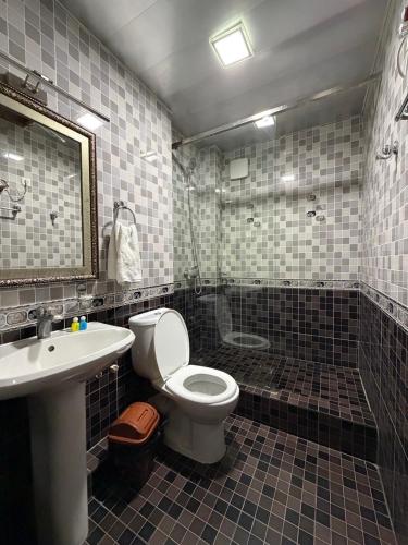 a bathroom with a toilet and a sink and a shower at Nur m hotel Free transfe hotel in airoport in Yakkasaray