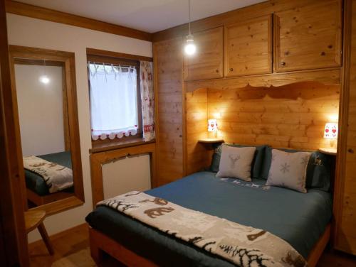 a bedroom with a bed in a wooden cabin at Appartamento Val Di Roda in San Martino di Castrozza