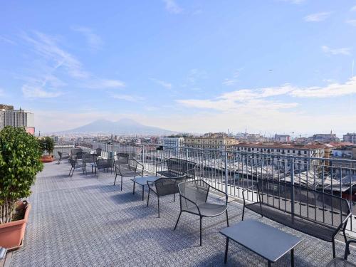 a balcony with chairs and tables on a building at B&B Hotel Napoli in Naples