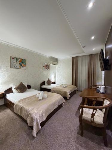 a hotel room with two beds and a television at Nur m hotel Free transfe hotel in airoport in Yakkasaray