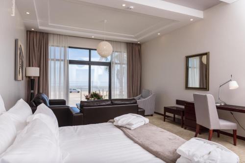 a hotel room with two beds and a desk at Flamingo Villas Boutique Hotel in Walvis Bay