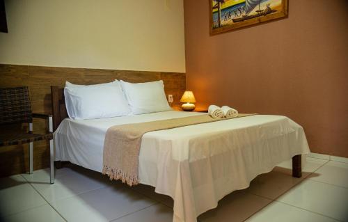 a bedroom with a bed with two towels on it at Pousada Sitio Araça in São Miguel dos Milagres