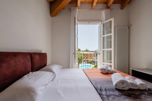 a bedroom with a large bed with towels on it at Corte Fasanella 50 in Toscolano Maderno