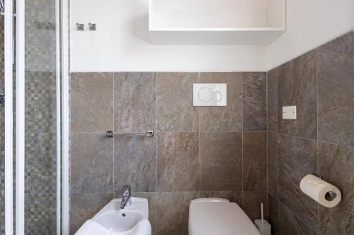 a bathroom with a white sink and a toilet at Corte Fasanella 50 in Toscolano Maderno