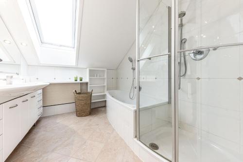 a white bathroom with a shower and a tub at Villa Stella all famous ski areas around us, 15 minutes to salzburg, mountainview in Golling an der Salzach