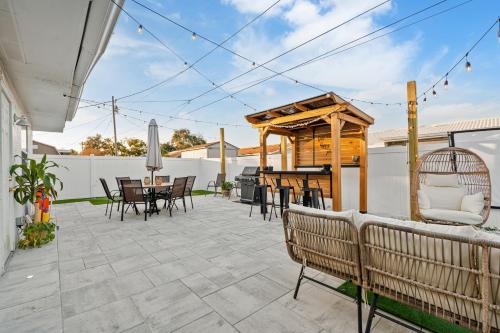 a patio with a table and chairs and a wooden pergola at Luxury Vacation Home in Madeira Beach Family and Pet Friendly in Seminole