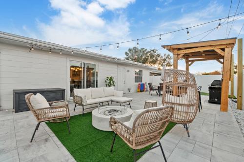 a patio with chairs and a table and a fireplace at Luxury Vacation Home in Madeira Beach Family and Pet Friendly in Seminole