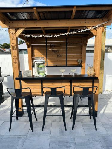 a wooden table with two chairs and a table with glasses at Luxury Vacation Home in Madeira Beach Family and Pet Friendly in Seminole