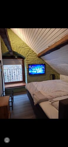 a bedroom with a bed and a tv on the wall at joseph in Monschau