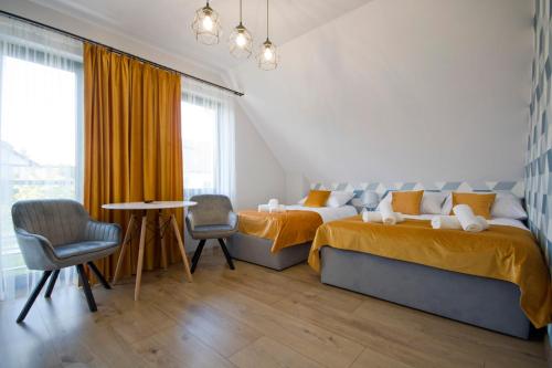 a bedroom with two beds and a table and chairs at Agroturystyka U Sadzy in Krajno Pierwsze