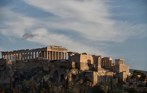 a view of the acropolis of athens against a cloudy sky at AIONION RESIDENCES by K&K in Athens