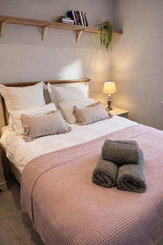 a bedroom with a large bed with two towels on it at Fernhill Hideaway in Charmouth