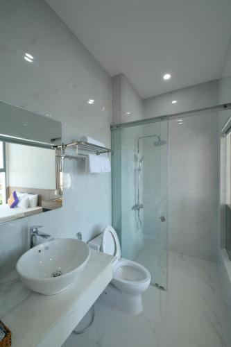 a bathroom with a sink and a toilet and a shower at Som Phu Quy 3 Hotel Phan Rang in Phan Rang–Tháp Chàm