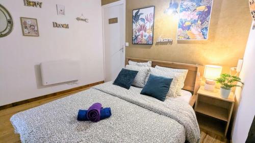 a bedroom with a large bed with a purple ribbon on it at Cosy Planta - 2 lits - Hyper Centre & Clémenceau - 1 parking sous terrain in Pau