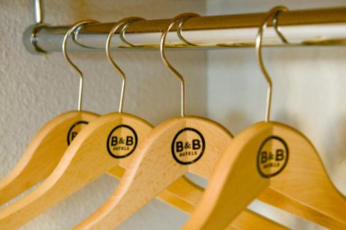 four wooden surfboards hanging on a rack at B&B HOTEL La Queue En Brie in La Queue-en-Brie