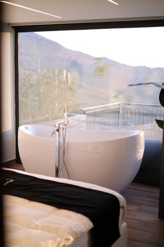 a white bath tub in a room with a window at Lyv Resort and Venue in Şannīn