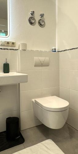 a white bathroom with a toilet and a sink at DUTTI'S HOME - 1 Zimmer Apartment, Küche, Self-Check-in, Stellplatz in Ingolstadt