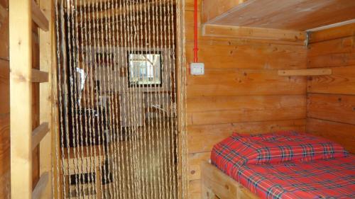ein Zimmer mit einem Bett in einer Holzhütte in der Unterkunft scuderia club house in Susa