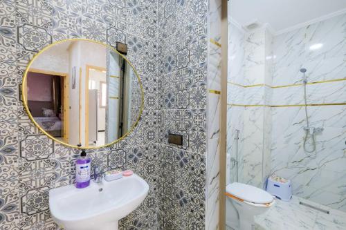 a bathroom with a sink and a mirror and a toilet at Riad Bollywood-Golden Stay D in Benguerir
