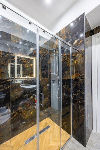 a bathroom with a shower with black tiles at Sant'Angelo Station in Naples
