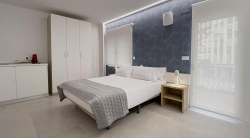 a bedroom with a large white bed and a side table at 6 de Mayo alojamientos in Almansa