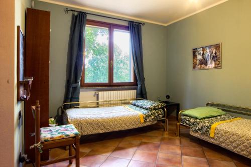 a bedroom with two beds and a window at Bay Cottage in Verrua Savoia