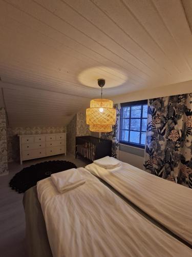 a bedroom with a large bed and a chandelier at Villa Juhala in Rovaniemi