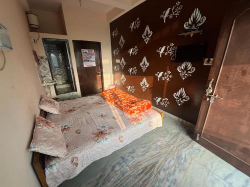 a bedroom with a bed with orange pillows on it at Krishna guest house in Sāmbhar