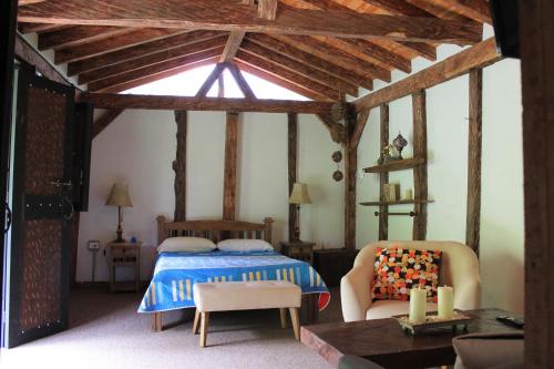 a bedroom with a bed and a chair in a room at Las Orquídeas EcoHostel in Guarne