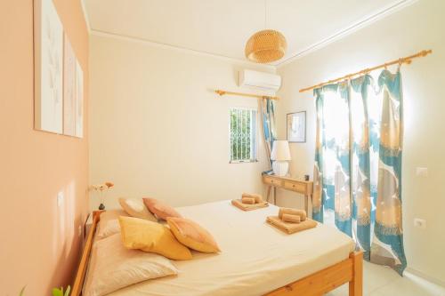 a bedroom with a bed with yellow pillows on it at Villa Antheon in Kalamákion
